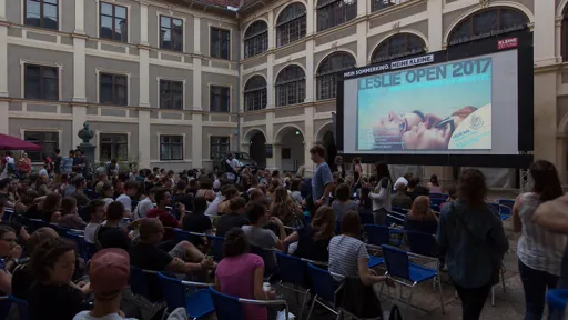 Kinoleinwand in Innenhof mit Zuseher